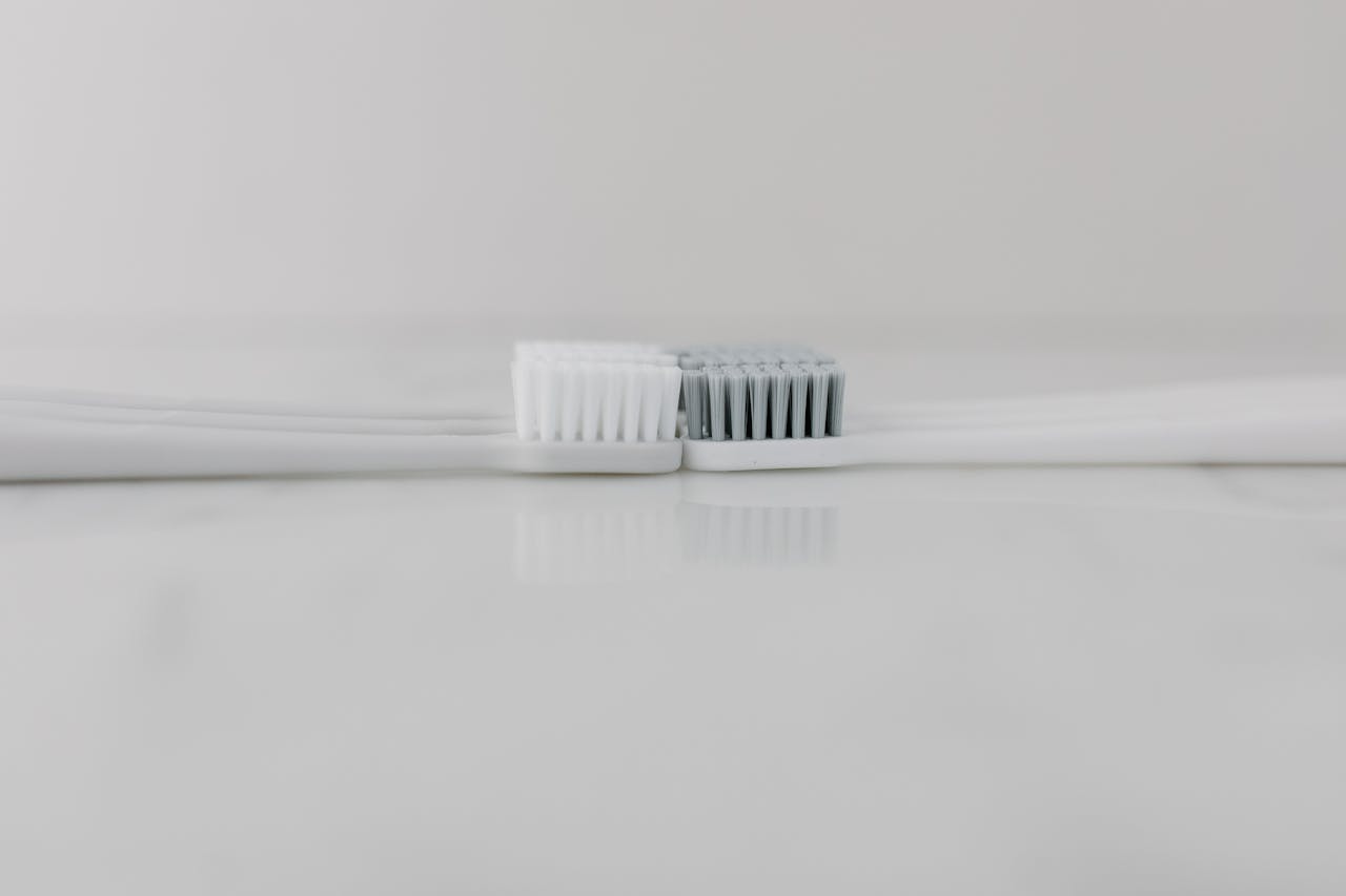 Close-up of two toothbrushes head-to-head on a marble background symbolizing oral care.